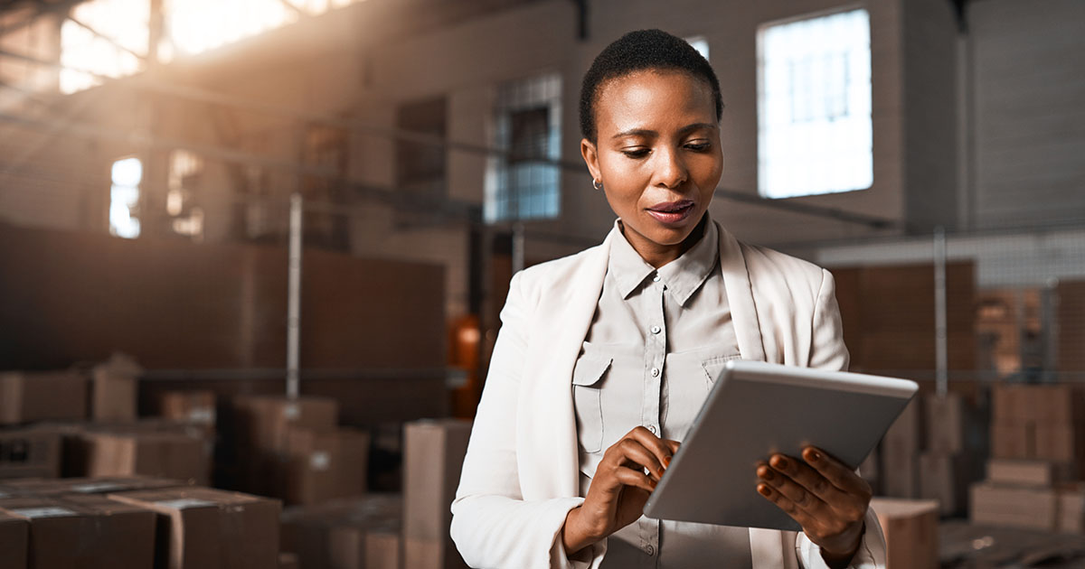A woman working in a warehouse on a tablet.