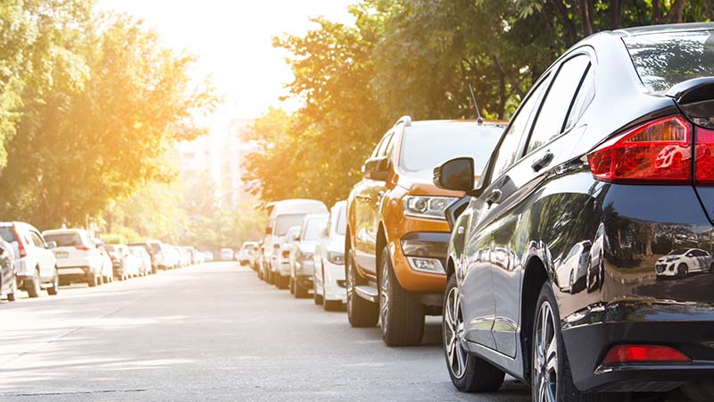 A line of cars parked on the street.