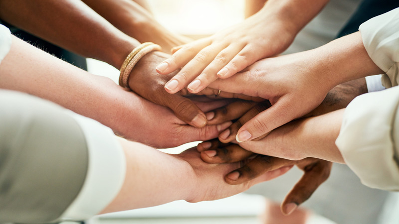 A group of people with their hands in a huddle.