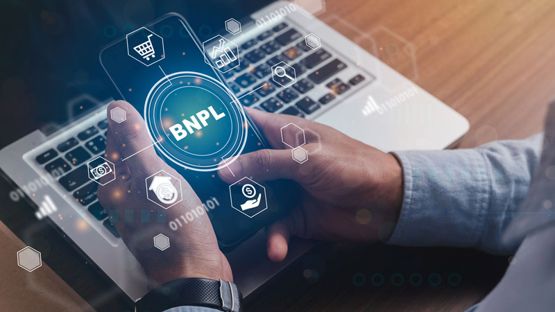 Person holding a smartphone with BNPL icons.