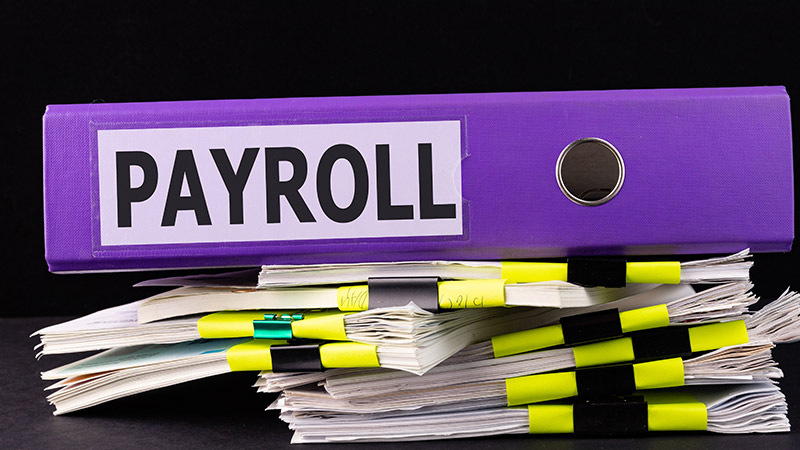 Payroll written on a large binder.