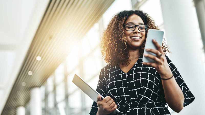 A woman using a smartphone and a tablet.