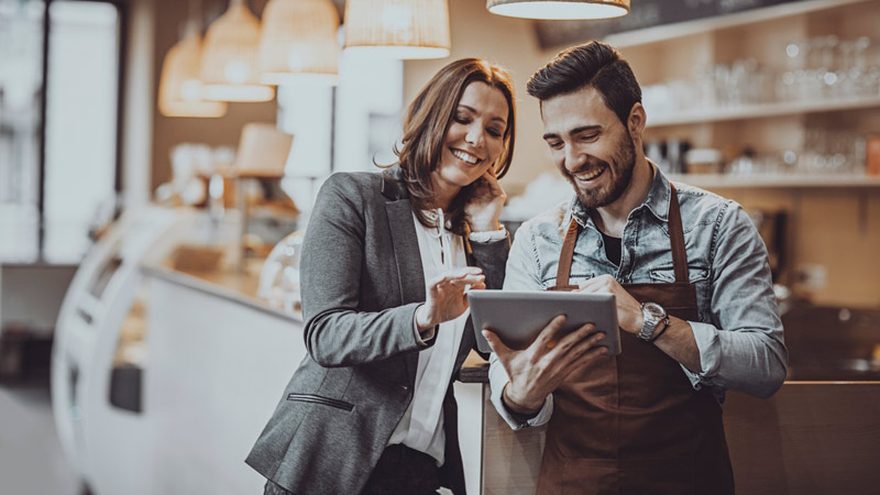 Two restaurant owners looking at a tablet.