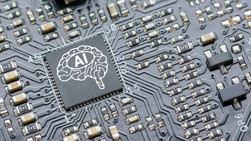 Computer chip with a brain graphic that says AI.