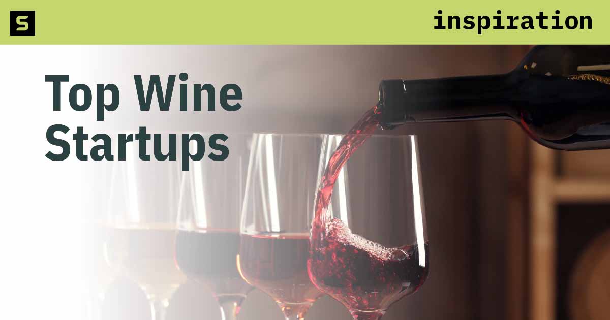 Smiling woman holding up glass of red wine.