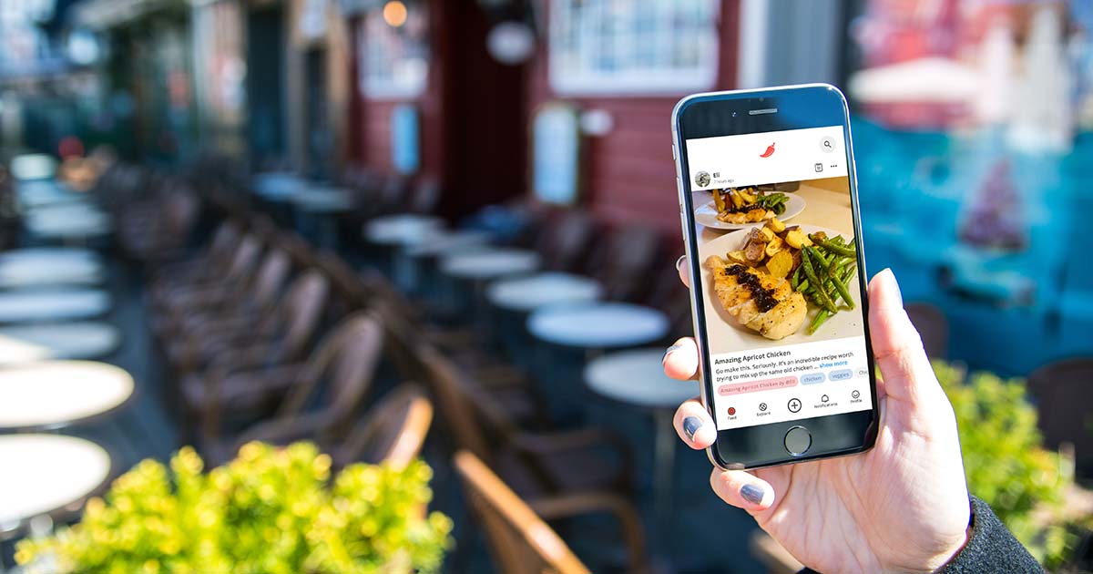 Hand holding phone with Pepper app on screen.