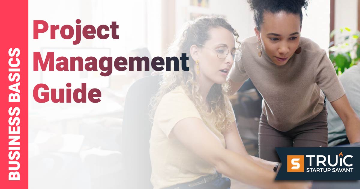 Two businesswomen using laptop in an office.