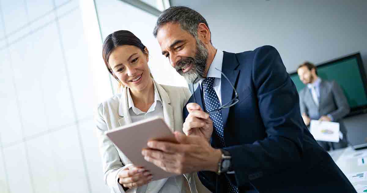 Two businesspeople looking over a tablet.
