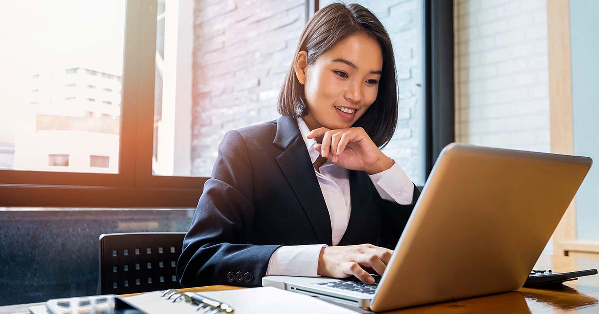 Smiling businesswoman at computer.